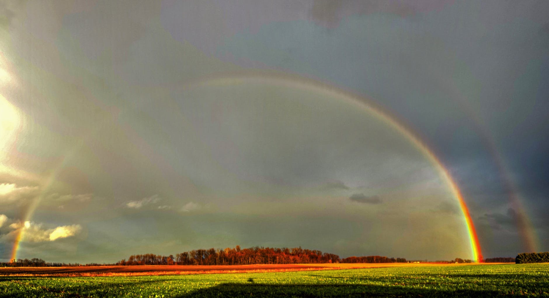 photography of green grass field with rainbow